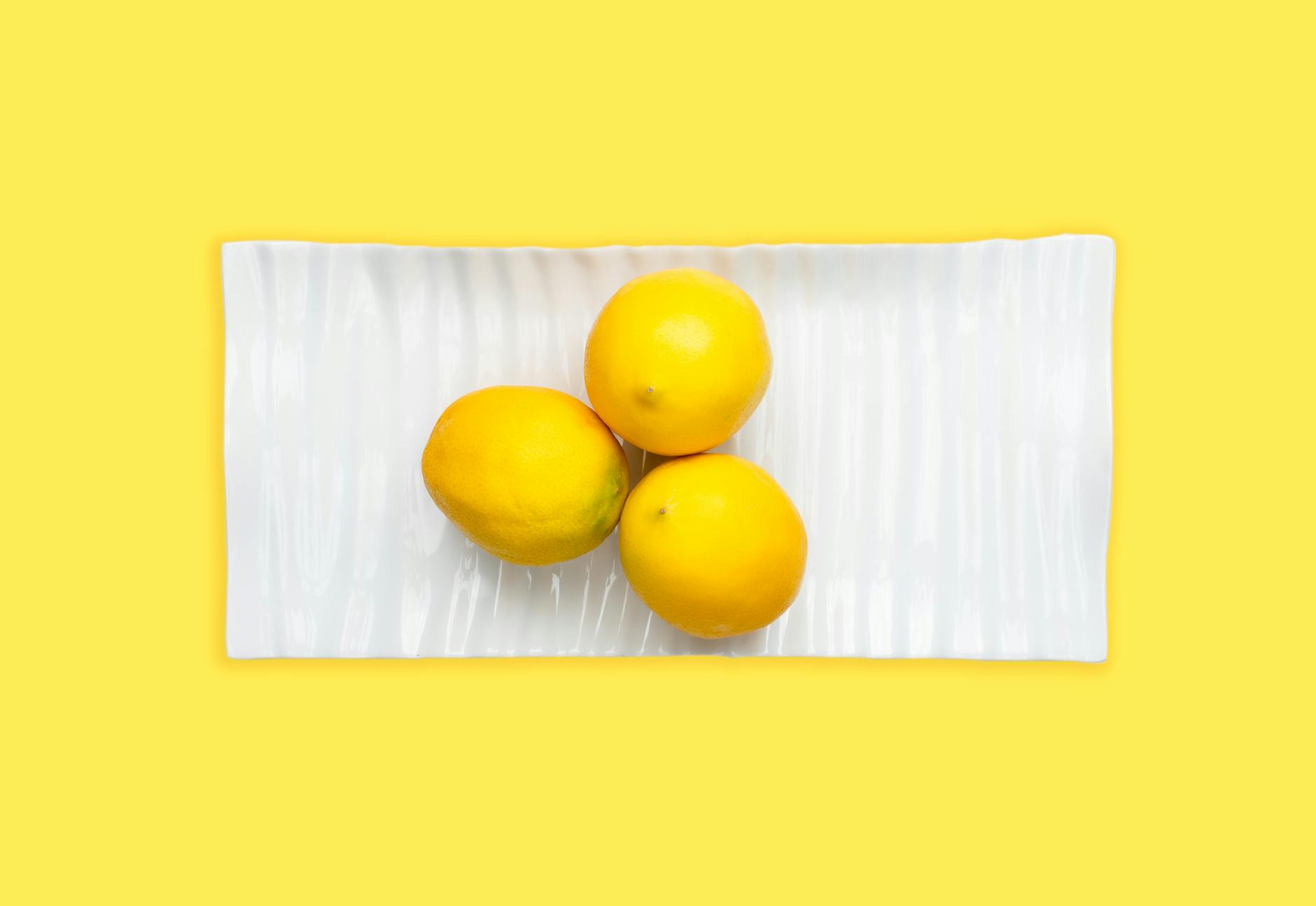 Two smiling women together with lemon slices, expressing joy and comfort indoors