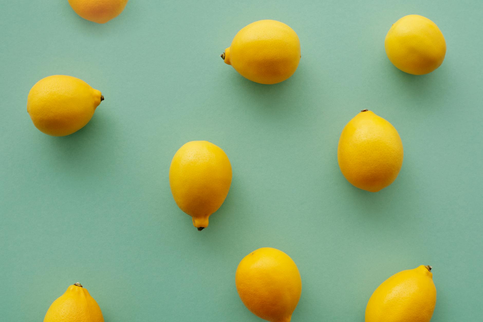 Bright yellow lemons arranged on a pastel green background, symbolizing fresh approaches to clitoral pleasure