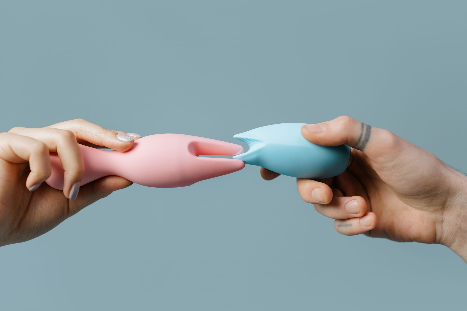 Close-up of hands holding a sleek blue vibrator, representing intimate self-care after medical treatment.
