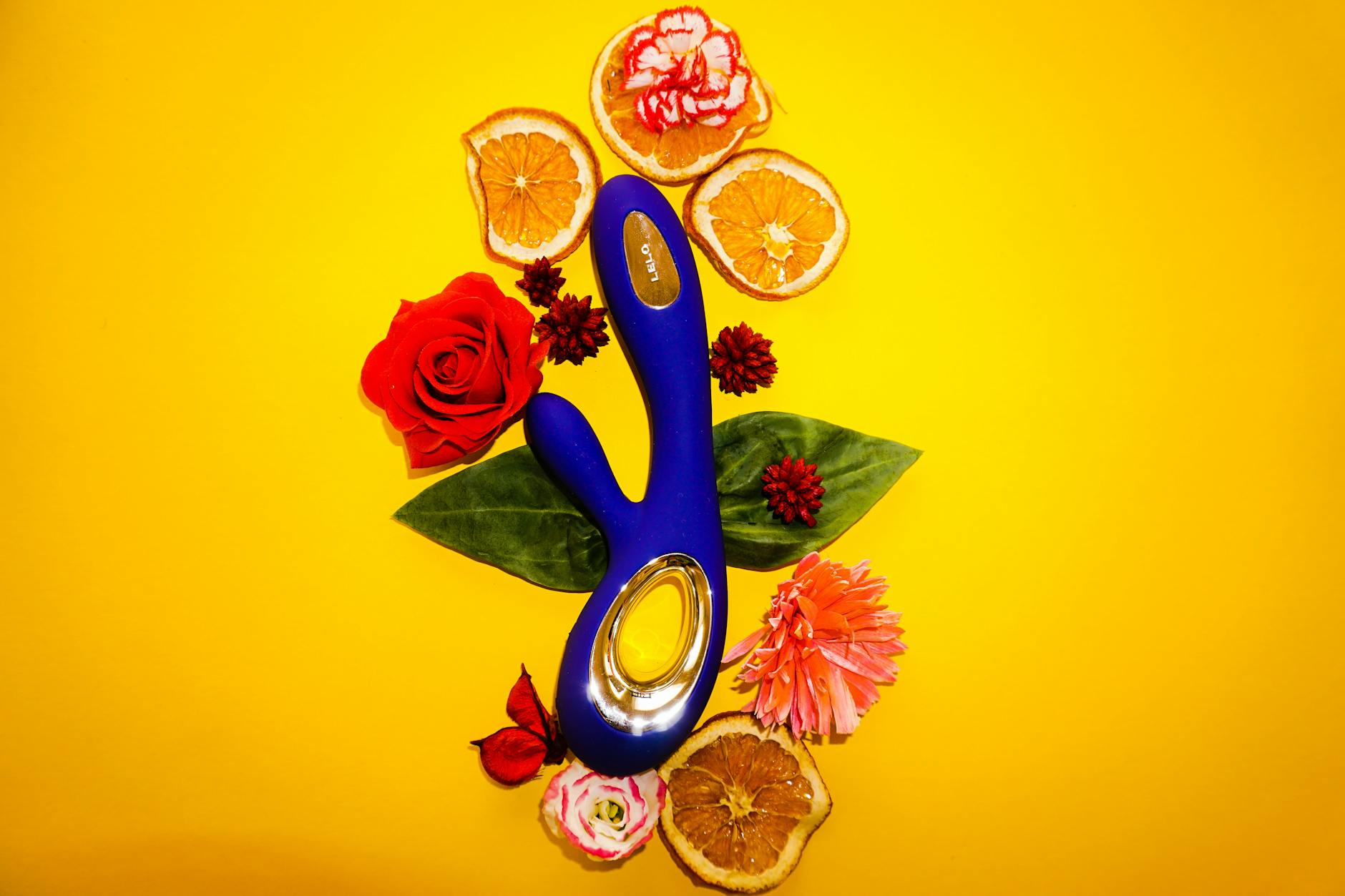 A yellow lemon vibrator surrounded by flowers on a yellow background, symbolizing fresh sensation and vibrant pleasure