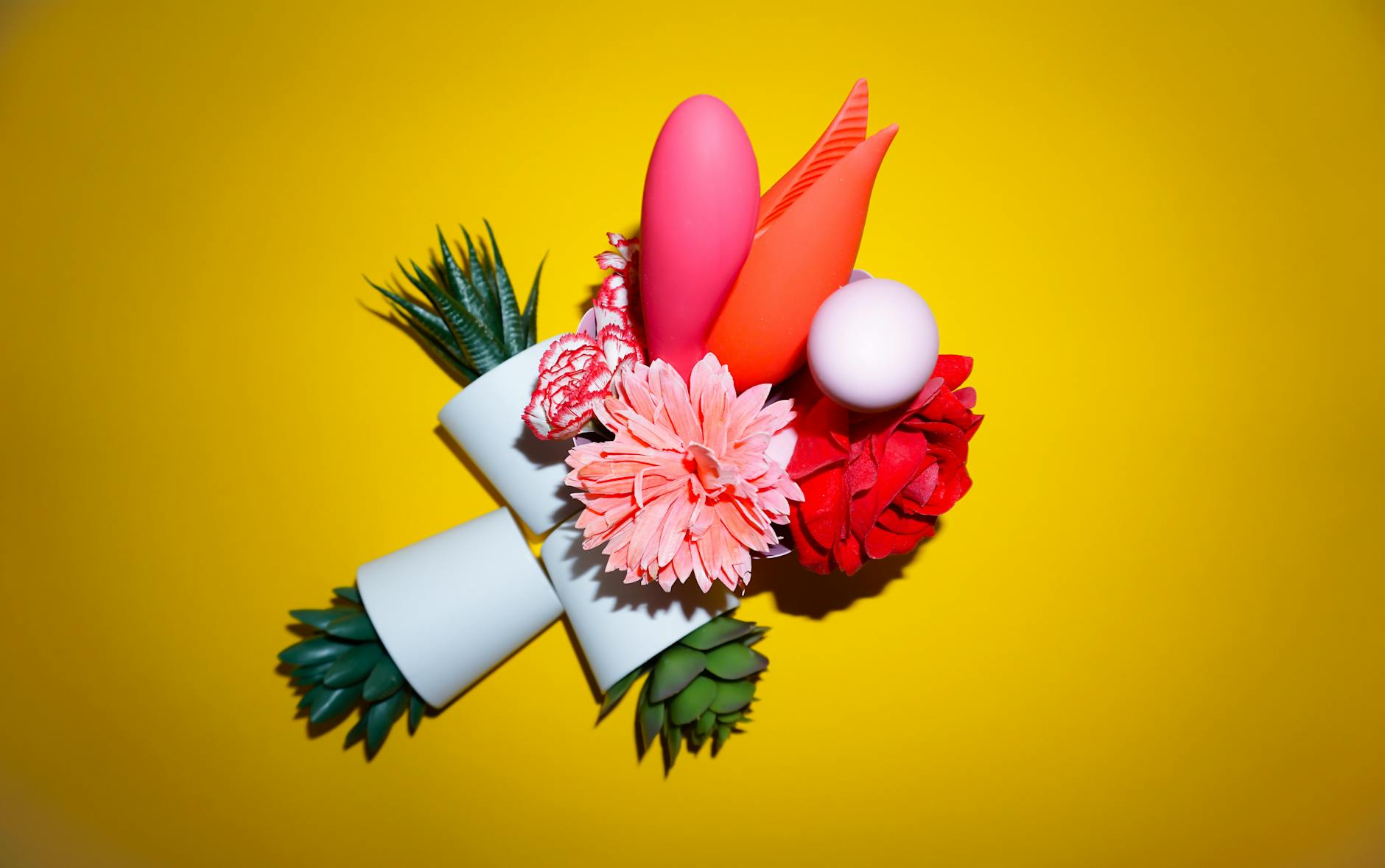 Collection of colorful vibrators displayed on a bright yellow background