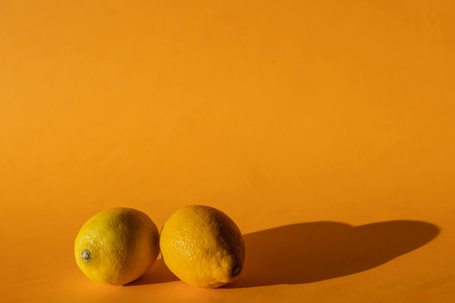 Bright vivid lemons on a yellow background, symbolizing renewal and vitality
